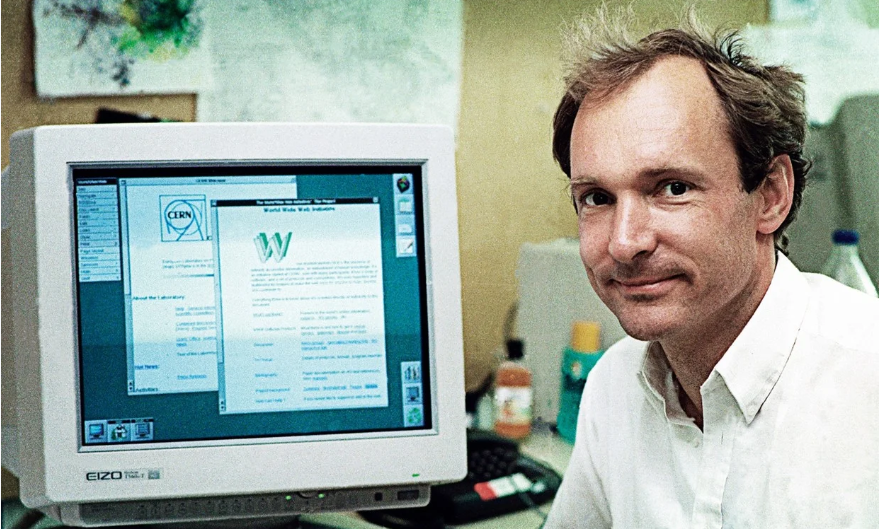 Tim Berners Lee, inventor of HTML, sitting on his computer